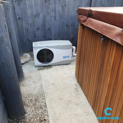 a smart heat pump install using the space between the swim spa & the retaining wall for output of airflow