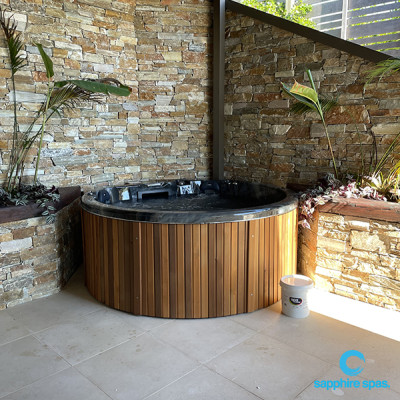 myHotTub with a natural stone wall backdrop thanks to the team @ Paramount Pools Auckland